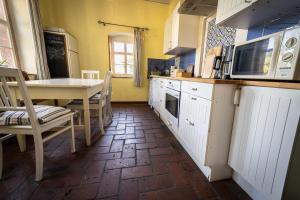 una cucina con armadi bianchi, tavolo e sedie di Haus Burgblick a Grimma Altre 20 foto