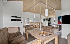 a living room with a couch and a table at Nice Home In Tarm With Sauna in Højsand