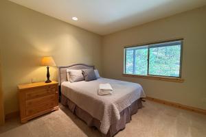 a bedroom with a bed with a lamp and a window at Tahoe Boulders in Stateline