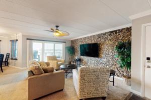 a living room with a couch and a tv on a wall at White Marlin 208B in Ocean City