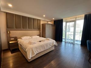 a bedroom with a large bed and a large window at Beautiful apartments near the sea Adlia street in Batumi