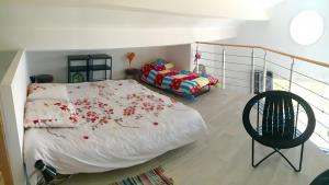 a bedroom with a bed with red flowers on it at Loft piscine chauffée et couverte in Sauvignac +21 photos