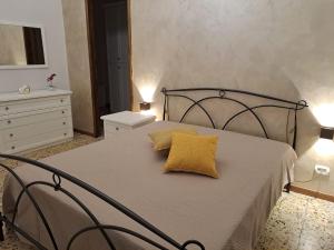 a bedroom with a bed with a yellow pillow on it at Il sorriso di Giuseppina in Bronte