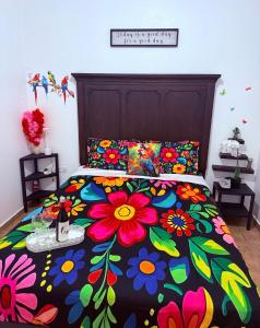 a bed with a colorful bedspread with flowers on it at Campo Adentro in Aguada