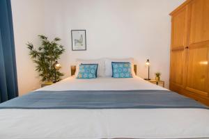 ein Schlafzimmer mit einem großen Bett und blauen Kissen in der Unterkunft Apartments Emmeline in Tisno