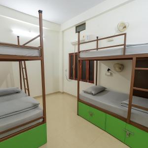 a room with three bunk beds in a room at Mosaic Hostel Varanasi in Varanasi