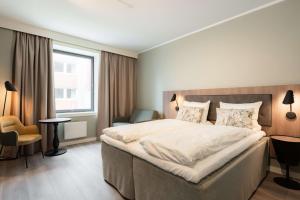 a hotel room with a large bed and a window at Quality Hotel Grand Tromsø in Tromsø