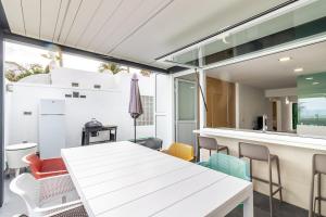 a dining room with a white table and chairs at Bungalow Einstein Xej in San Bartolomé