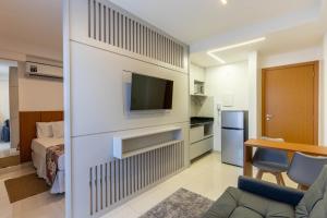 ein Wohnzimmer mit einem Bett und einem TV in einem Zimmer in der Unterkunft Venice Park Hplus Long Stay in Brasilia