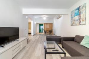 a living room with a couch and a tv at Bungalow Einstein Xej in San Bartolomé