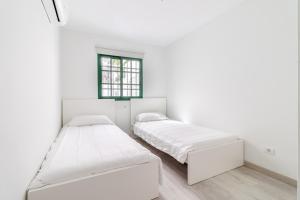 two beds in a white room with a window at Bungalow Einstein Xej in San Bartolomé +41 photos