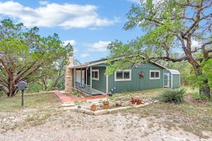 a green tiny house in a yard with trees at Napping Fox Cottage in Cranes Mill