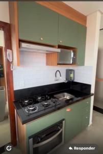 a kitchen with a stove and a sink at Apartamento Completo com 2 Camas in Euclides da Cunha +4 photos