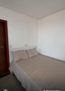 a white bed with two pillows in a room at Apartamento Completo com 2 Camas in Euclides da Cunha