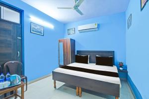 een slaapkamer met een bed in een blauwe kamer bij Hotel O by OYO Deep in Kānota