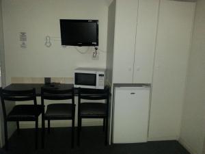 a room with a table with chairs and a microwave at Bargo Motor Inn in Bargo