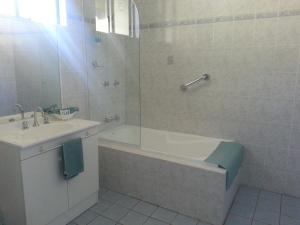 a bathroom with a tub and a sink and a shower at Bargo Motor Inn in Bargo