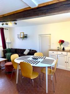a living room with a white table and yellow chairs at La maison des Hortillonnages, le calme dans Amiens in Rivery