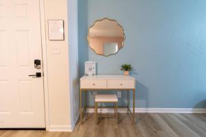 a desk with a chair and a mirror on a blue wall at Pet Friendly Stylish Condo Near Campus in Gainesville