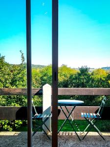 une table et des chaises assises devant une porte vitrée dans l'établissement Villa Hortensia - Charming Cottage Near Fontainebleau, à Veneux-les-Sablons