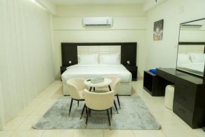 a bedroom with a bed and a table and chairs at اونيسن البري Onesn Albari in Unayzah