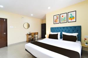 une chambre avec un grand lit avec une tête de lit bleue dans l'établissement Townhouse VSK group of hotels, à Hyderabad