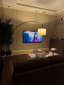 Una sala de estar con un sofá y un televisor de pantalla plana. en شقة في البساتين, en Yeda