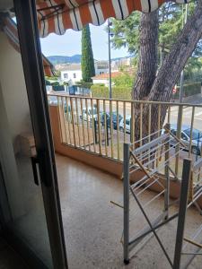 a balcony with an umbrella and a tree at Appartement proche centre ville 10min à pied de la mer in Mandelieu-la-Napoule