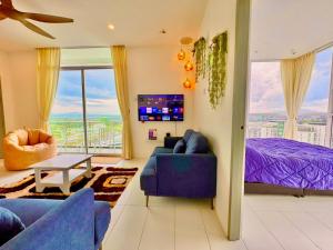 a living room with a blue couch and a bed at TT3 SOHO 2BR HIGH Flr CORNER BALCONY UNIMAS SAMARAHAN in Kuching