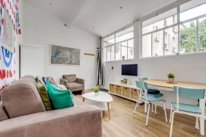 a living room with a couch and a table at The Tour Pavilion - Calm and Bright in Paris