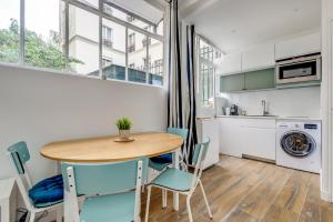 a kitchen and dining room with a table and chairs at The Tour Pavilion - Calm and Bright in Paris