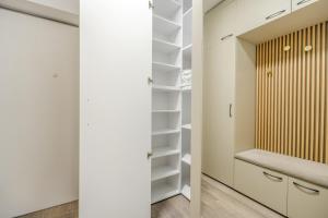 Elle comprend un dressing avec des murs blancs et des armoires blanches. dans l'établissement Sunset View Pipera 56 Blvd Ivory, à Bucarest 34 autres photos