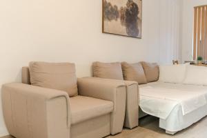 un salon avec un canapé et une chaise dans l'établissement Sunset View Pipera 56 Blvd Ivory, à Bucarest