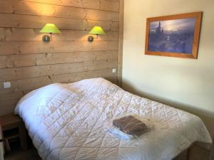 a bedroom with a bed with two lamps on the wall at Duplex 3 pièces 6-7 pers centre, ski au pied - FR-1-513-81 in La Tania