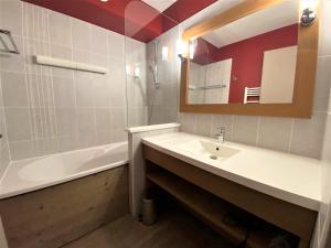 a bathroom with a sink and a tub and a mirror at Duplex 3 pièces 6-7 pers centre, ski au pied - FR-1-513-81 in La Tania