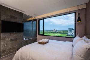 - une chambre avec un grand lit blanc et une grande fenêtre dans l'établissement Angel's Inn, à Jiaoxi