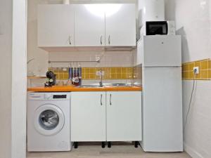 a kitchen with a white refrigerator and a washing machine at Cadizz- Estudio Las Flores in El Puerto de Santa María