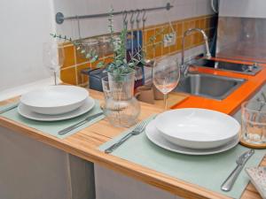 a kitchen counter with plates and glasses and a sink at Cadizz- Estudio Las Flores in El Puerto de Santa María +10 photos