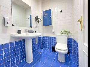 a blue and white bathroom with a toilet and a sink at Cadizz- Estudio Las Flores in El Puerto de Santa María