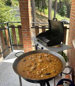 eine Pfanne mit Essen auf einem Grill mit einem Laptop in der Unterkunft Casa Rural Las Pegueras in Cuevas del Valle