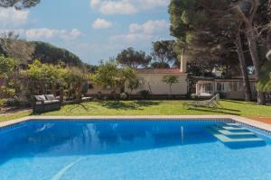 a pool in front of a house with a yard at Cadizz - Villa Verde- La Barrosa in Chiclana de la Frontera