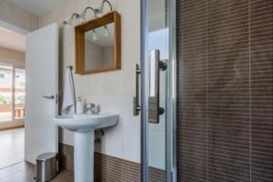 a bathroom with a sink and a glass shower at Cadizz-Ático El Falla con terraza de 40m2 in Cádiz +42 photos