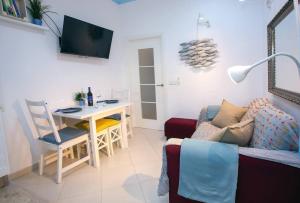a living room with a couch and a table and a desk at Terraza junto a La Caleta El Faro del Manteca I in Cádiz