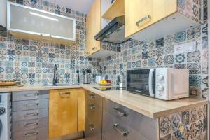 a small kitchen with a microwave and a counter at Cadizz Entre Cielo y Mar Centro del Puerto ciudad in El Puerto de Santa María +33 photos