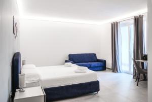 ミラッツォにあるMilazzo Holiday Apartments&Rooms - LiveLoveTravelのベッドと青いソファのある寝室