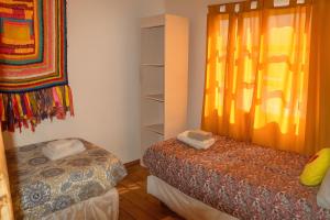 a room with two beds and a window at Tem Kotenkesh Dpto Macatobiano 4 pax in El Calafate