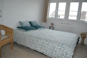 a bedroom with a bed with blue pillows on it at 3 Chambres pour 2 à 6 pers Paris Ouest B&B in Rueil-Malmaison