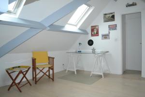 a room with a table and a desk in a attic at 3 Chambres pour 2 à 6 pers Paris Ouest B&B in Rueil-Malmaison