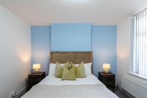 a bedroom with a bed with pillows and two lamps at Spacious 3BR Home - Comfort & Convenience in Manchester