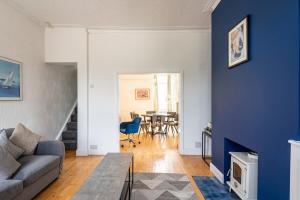 a living room with a couch and a blue wall at Spacious 3BR Home - Comfort & Convenience in Manchester